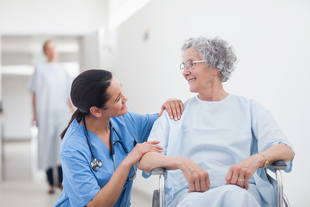 Elderly patient looking at a nurse in hospital ward
